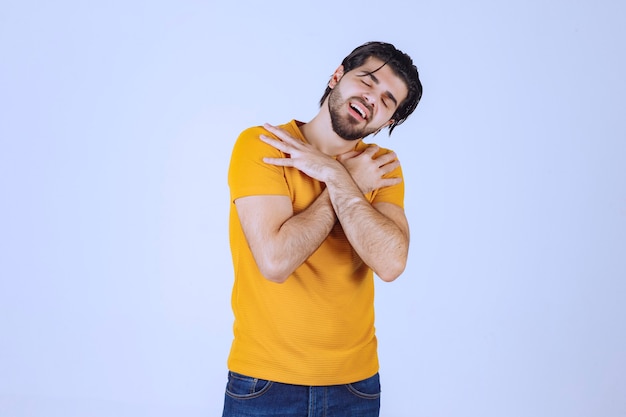 Homem de camisa amarela fazendo poses sedutoras e atraentes