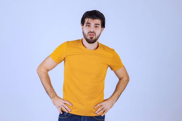 Homem de camisa amarela fazendo poses sedutoras e atraentes