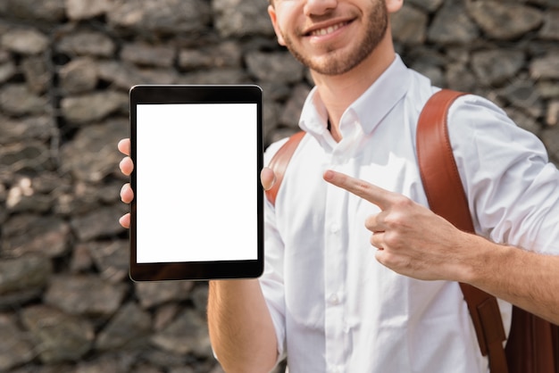 Homem de camisa branca, apontando para o seu tablet