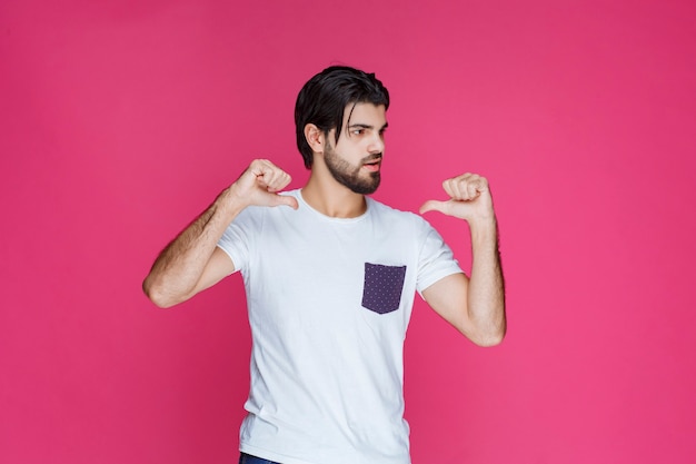 Homem de camisa branca, apontando para si mesmo.