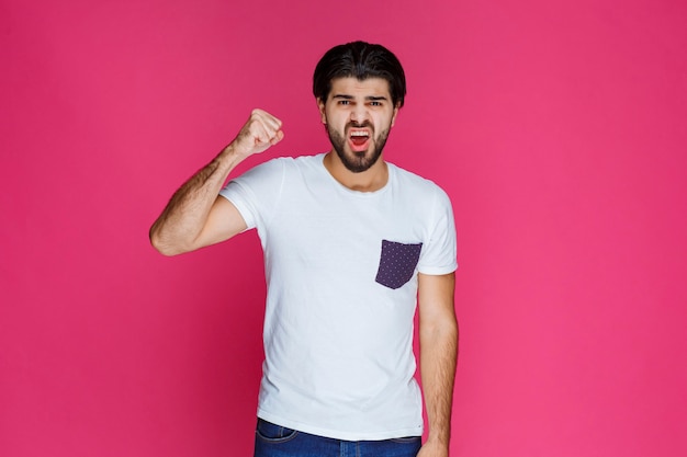 Foto grátis homem de camisa branca, mostrando os punhos e o poder.