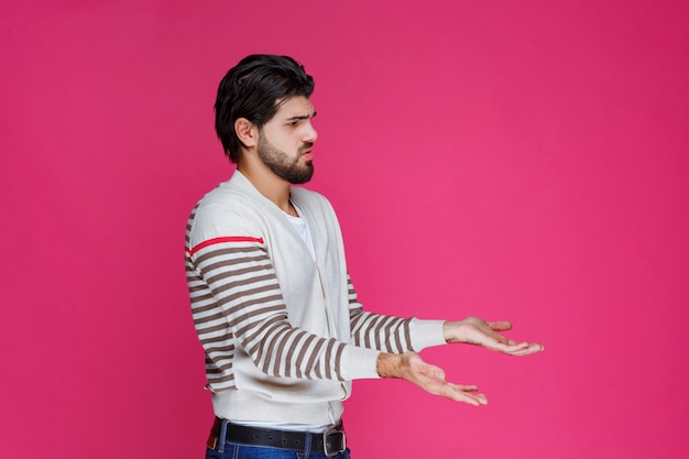 Homem de camisa branca mostrando que não tem ideia sobre o assunto.