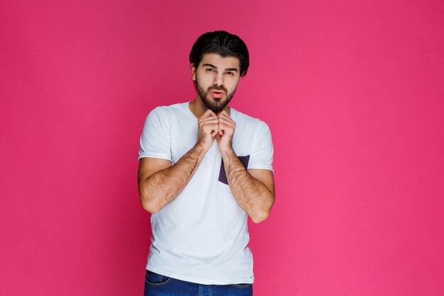 Homem de camisa branca parece apavorado e assustado.