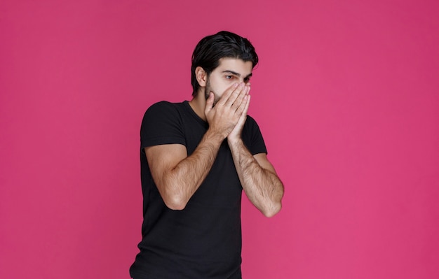 Foto grátis homem de camisa preta parece chocado e cansado com alguma coisa