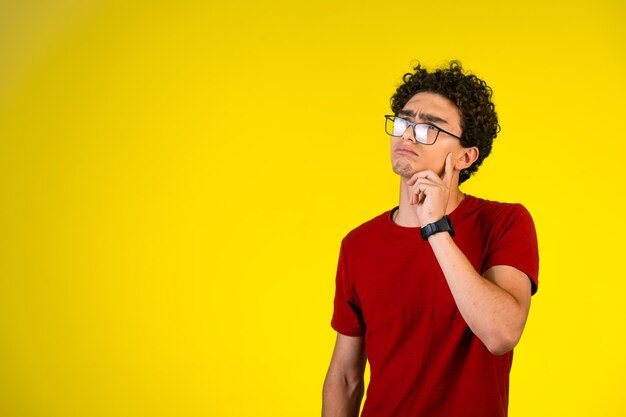 Foto grátis homem de camisa vermelha coloca a mão no peito e pensa