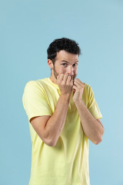 Homem de camiseta amarela posando para um retrato de estúdio