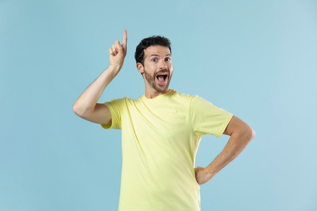 Homem de camiseta amarela posando para um retrato de estúdio