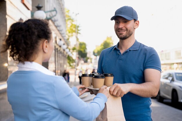 Homem de camiseta entregando comida para viagem