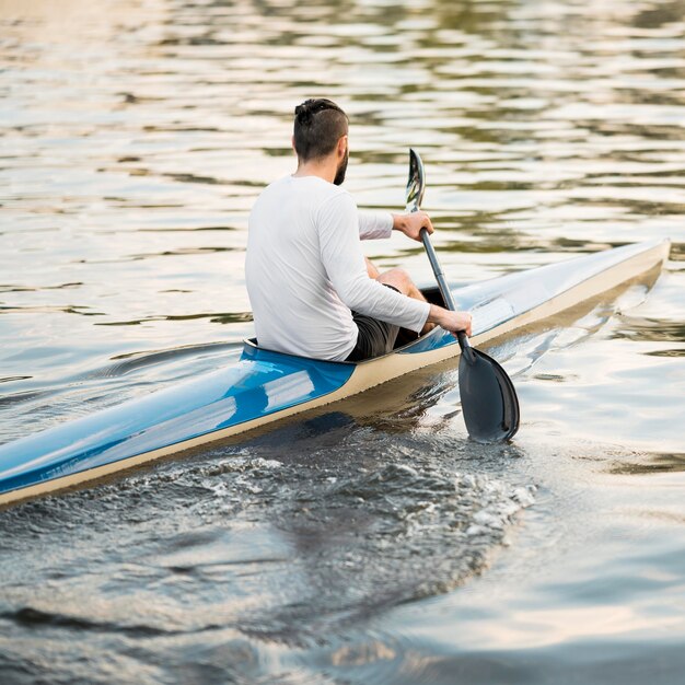 Homem de canoa no lago