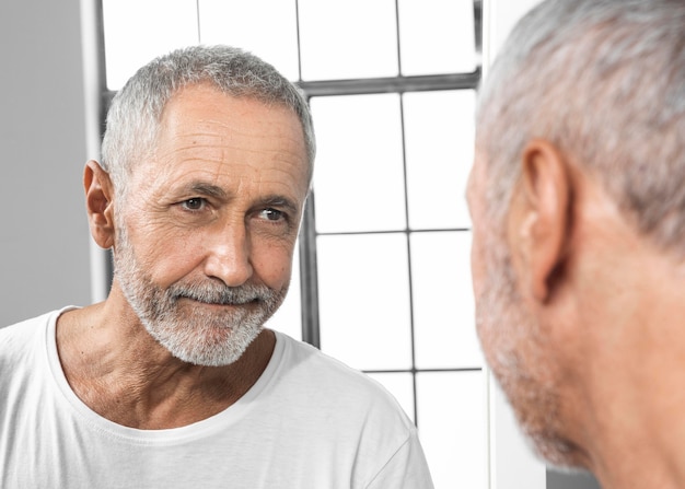 Foto grátis homem de close-up se olhando no espelho