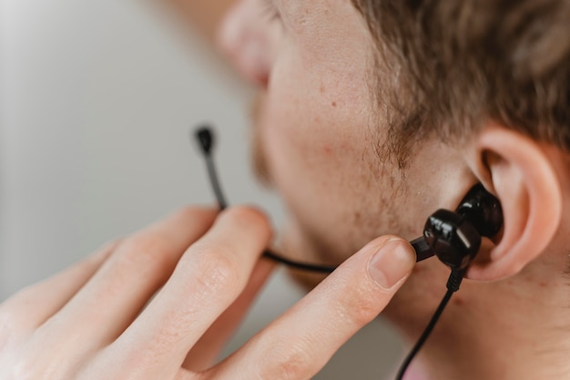 Homem de close-up usando fones de ouvido