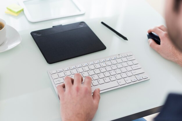 Homem de colheita usando o computador de escritório