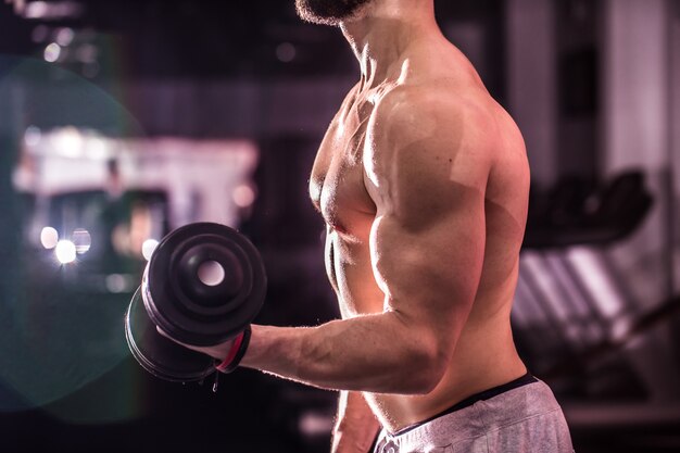 Homem de esportes musculares está envolvido no treinamento de cross fit na academia, o conceito de esporte