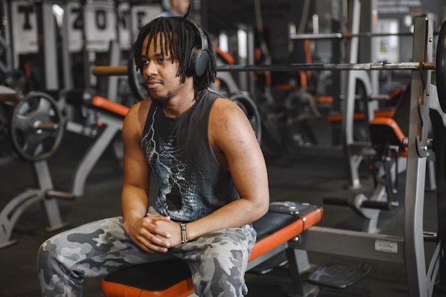 Foto grátis homem de esportes no ginásio. um homem negro realiza exercícios. cara em uma camiseta preta