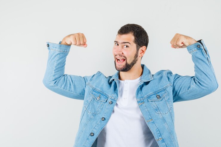 Foto grátis homem de estilo retro mostrando os músculos dos braços na jaqueta, camiseta e parecendo alegre. vista frontal.