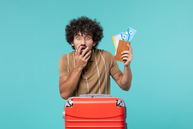 homem de férias segurando ingressos no azul