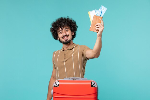 homem de férias segurando ingressos no azul