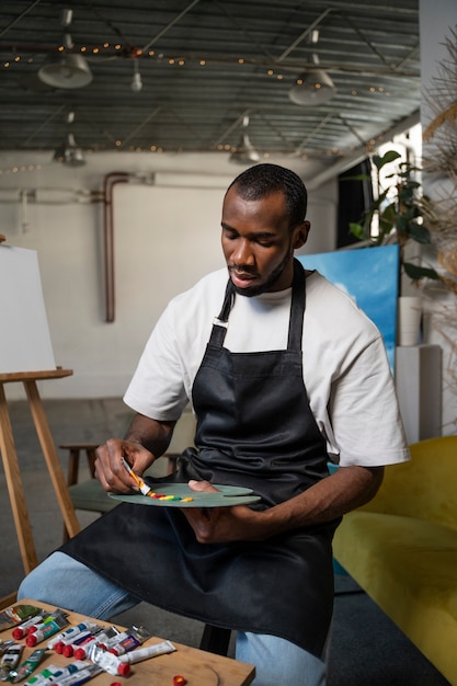 Foto grátis homem de frente segurando uma paleta de pintura