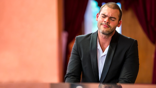 Homem de frente tocando piano dentro de casa