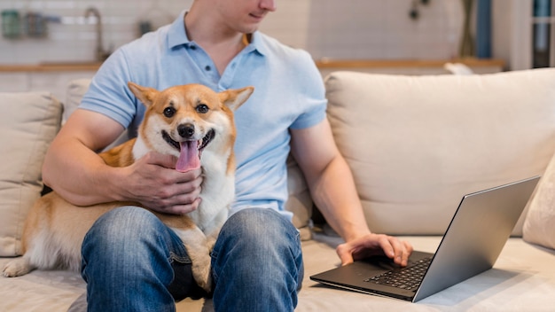 Foto grátis homem de frente trabalhando enquanto segura um cachorro