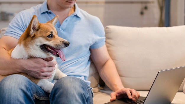 Homem de frente trabalhando enquanto segura um cachorro