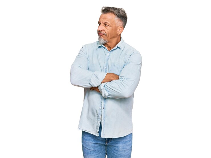 Foto grátis homem de idade média de cabelos grisalhos vestindo roupas casuais olhando para o lado com os braços cruzados convencido e confiante
