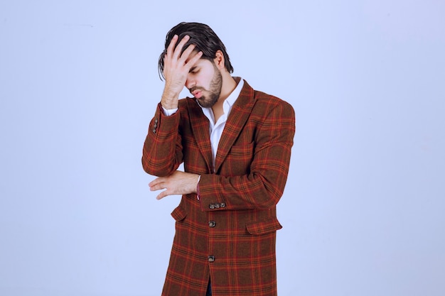Homem de jaqueta xadrez, sentindo-se muito triste com algo e chorando.