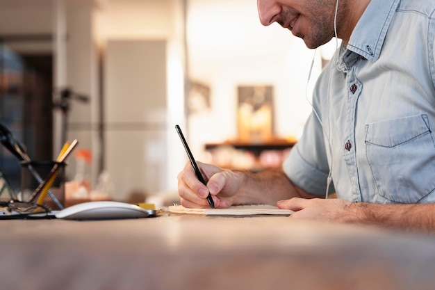 Homem de lado fazendo freelance em casa