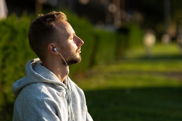 Homem de lado ouvindo música enquanto medita
