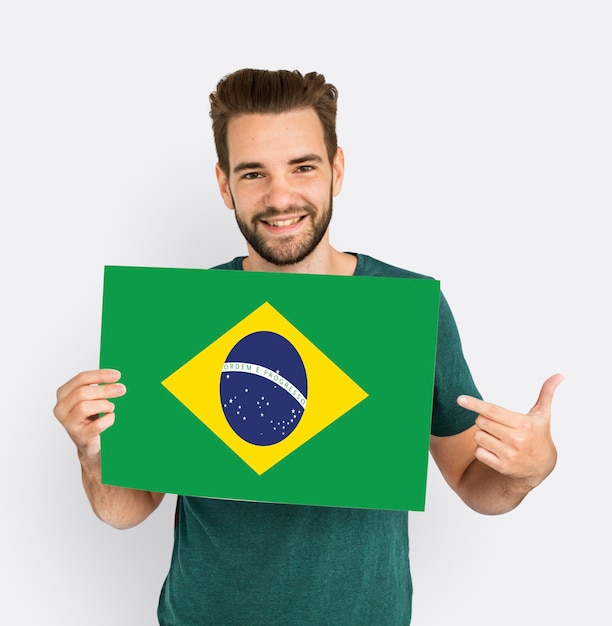 Foto grátis homem de mãos dadas com o patriotismo da bandeira do brasil