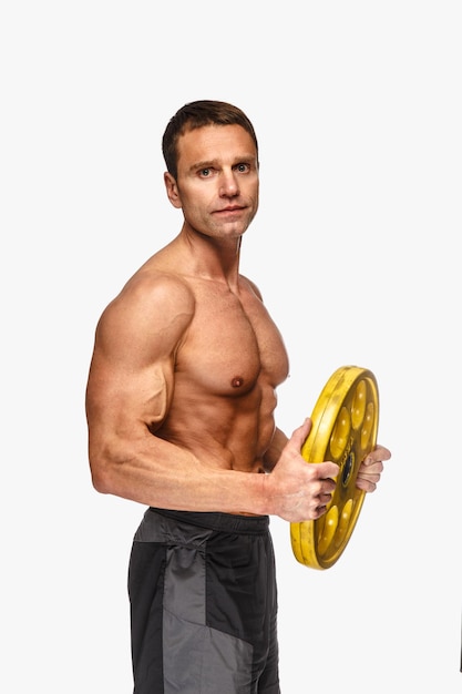 Foto grátis homem de meia idade sem camisa desportivo segurando o peso da barra amarela. isolado no fundo branco.