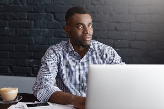 Homem de negócios afro-americano atraente trabalhando remotamente