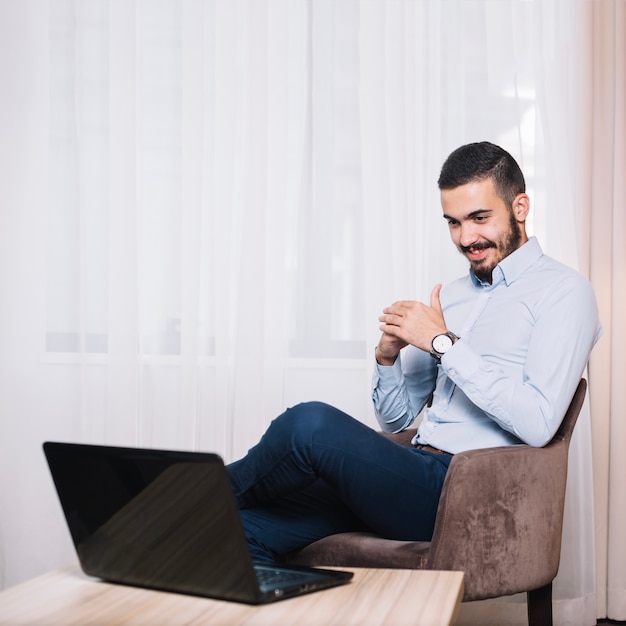 Homem de negócios alegre no laptop