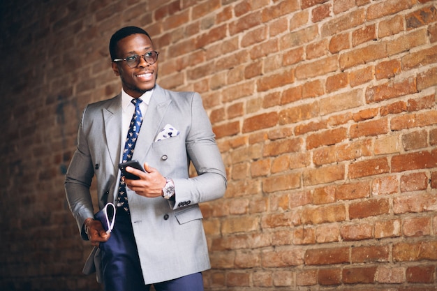 Homem de negócios americano africano com telefone