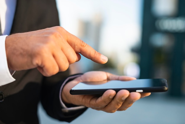 Homem de negócios ao ar livre em close-up e telefone celular