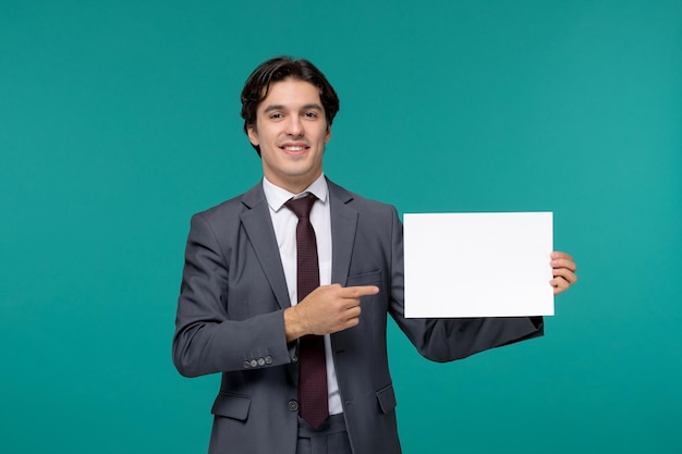 Homem de negócios bonito bonitão de terno cinza e gravata sorrindo segurando folhas de papel