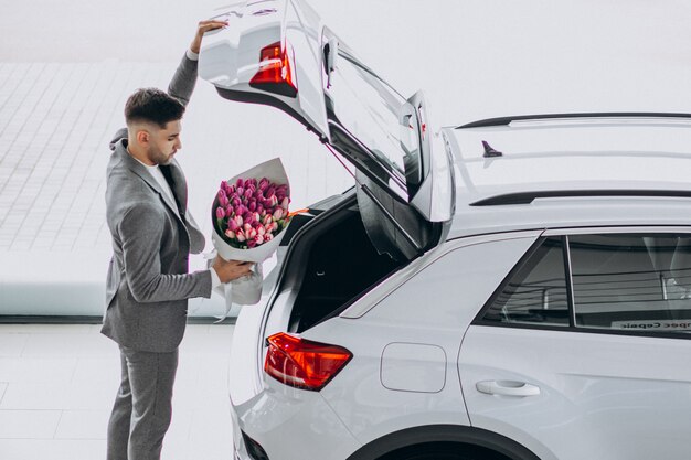 Homem de negócios bonito jovem entregando buquê de flores lindas