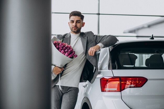 Homem de negócios bonito jovem entregando buquê de flores lindas