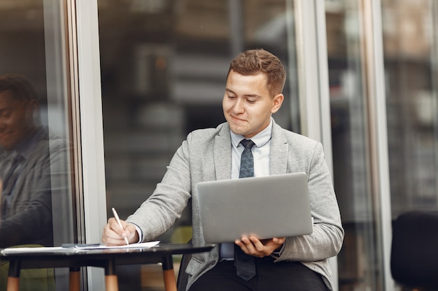 Foto grátis homem de negocios. cara de terno. malw usa um laptop.