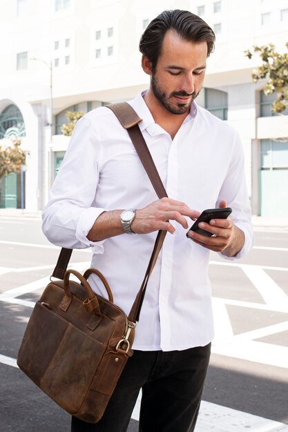 Homem de negócios casual com camisa branca a caminho do trabalho ao ar livre para uma sessão de fotos