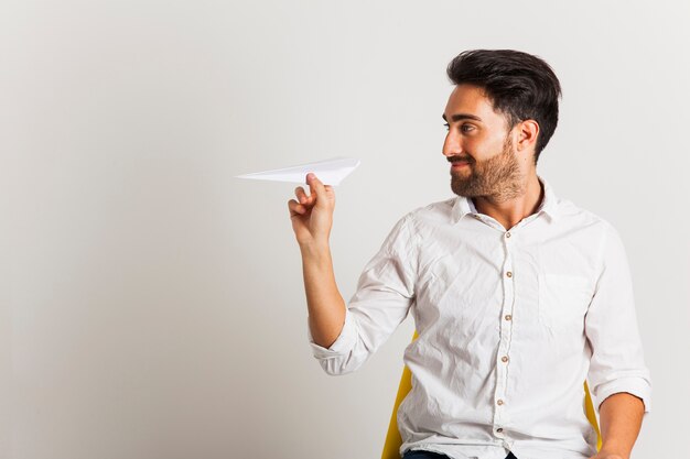 Homem de negócios com papel avião no escritório