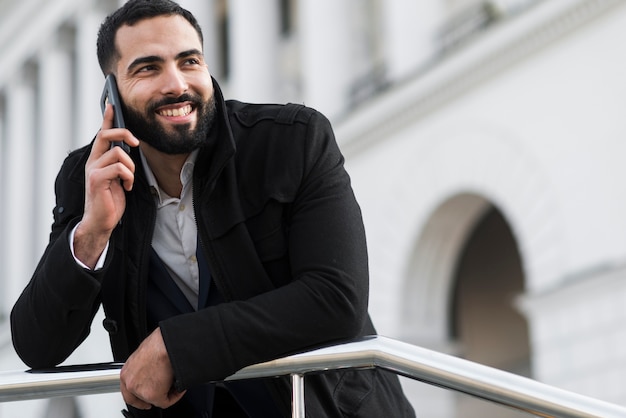 Homem de negócios de baixo ângulo falando por telefone