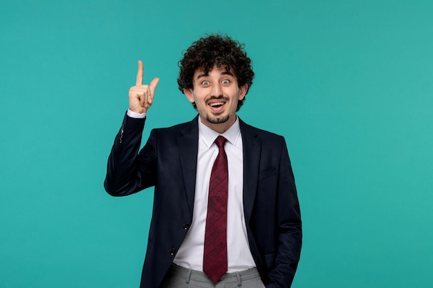 Homem de negócios encaracolado bonitinho de terno preto bingo feliz por uma ideia