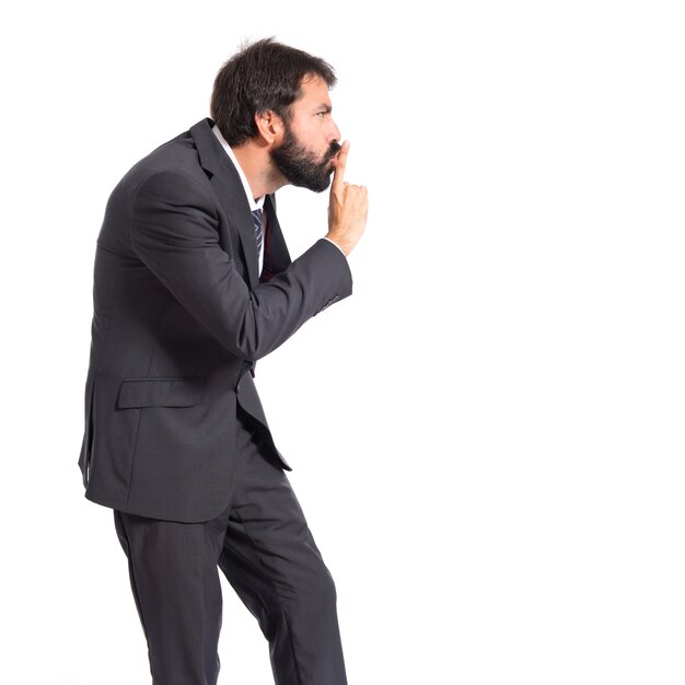 Homem de negócios fazendo o gesto de silêncio sobre o fundo branco isolado