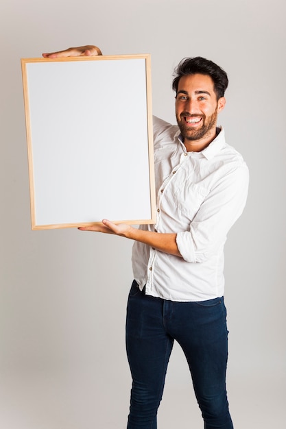 Homem de negócios feliz segurando quadro branco