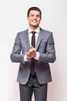 Foto grátis homem de negócios feliz vestindo terno cinza isolado na parede branca