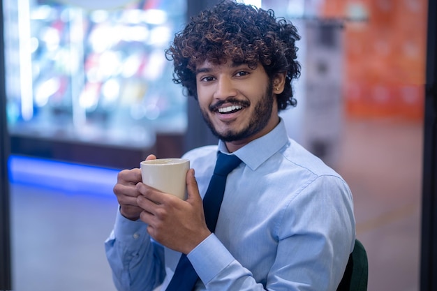 Homem de negocios. Jovem empresário elegante com uma xícara nas mãos