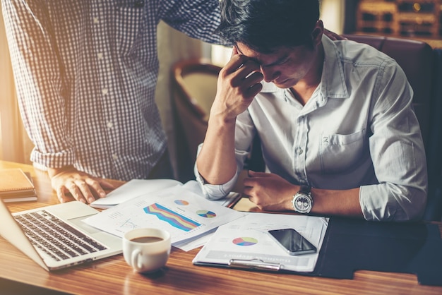 Homem de negócios novo sério que olha o relatório financeiro parecer