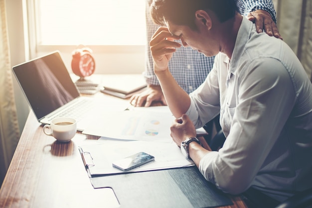 Homem de negócios novo sério que olha o relatório financeiro parecer