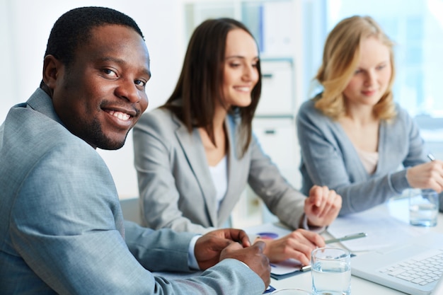 Foto grátis homem de negócios positivo com os colegas de trabalho